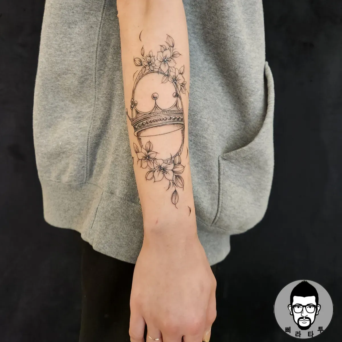 팔 라인워크 타투: 왕관과 꽃의 조화